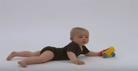 Малыш тянется за игрушкой